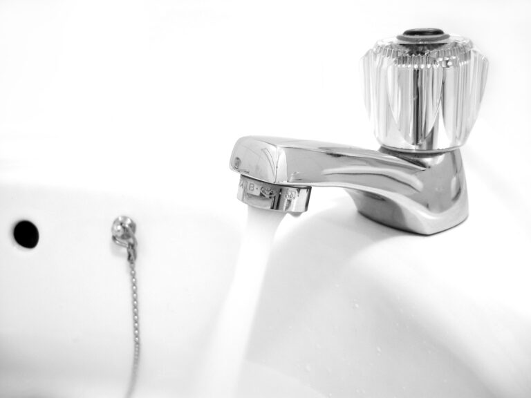Tap water flowing from a kitchen faucet, commonly used for watering houseplants
